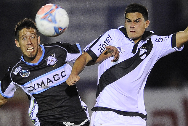 Javier García (Wanderers) y Guillermo Cotugno (Danubio) forcejean en el partido de ida. Se espera otro partido duro para el domingo.